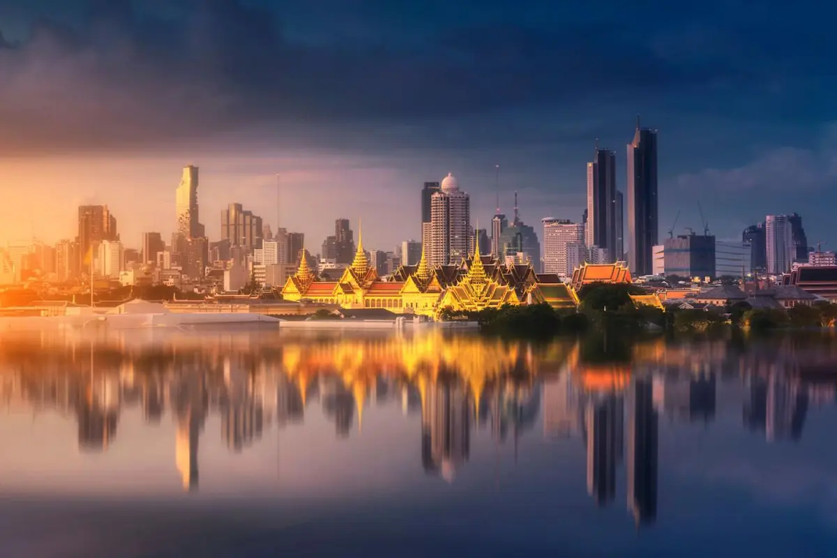 Vista de Bangkok al atardecer con templos y rascacielos junto al rÃo